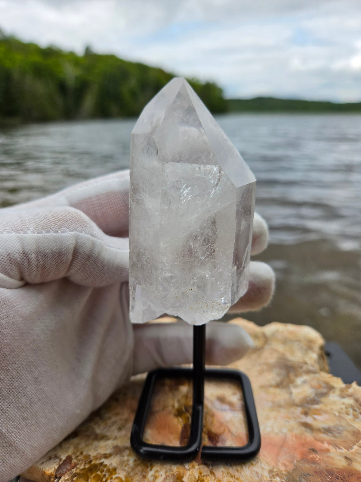 Clear quartz crystal on stand side view