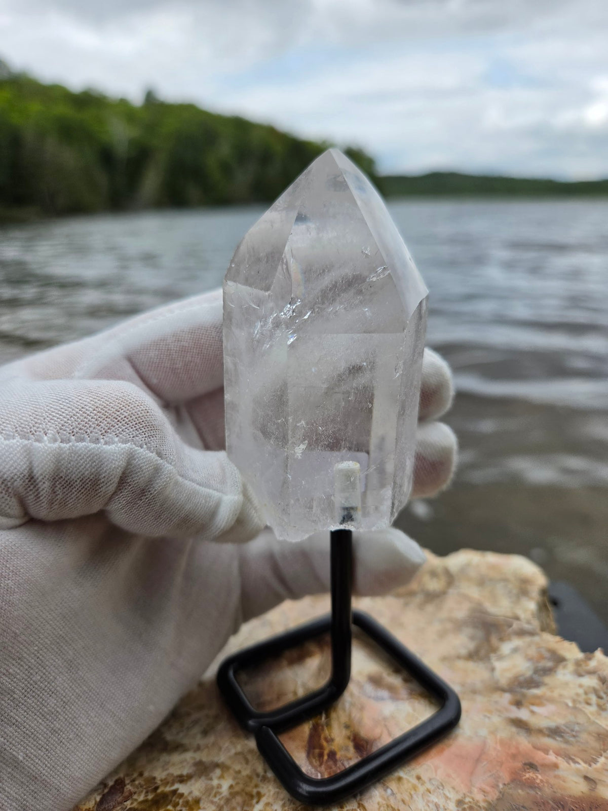 Clear quartz crystal on stand front view