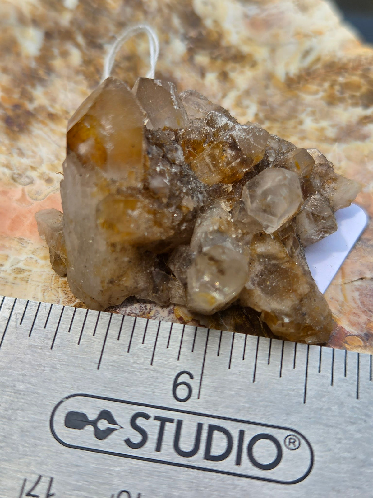 Pineapple quartz cluster closeup with ruler