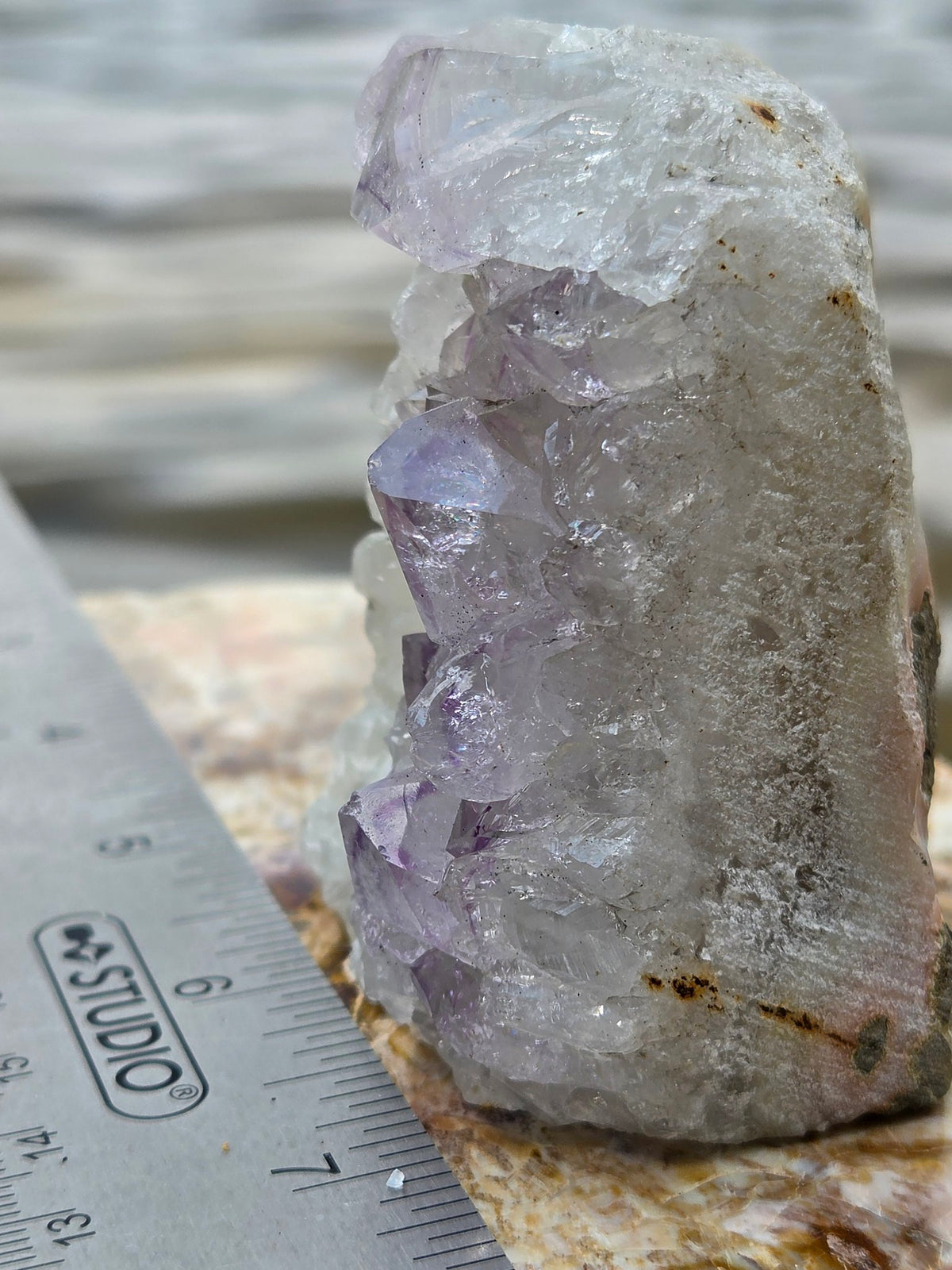 Amethyst cluster with ruler, back view