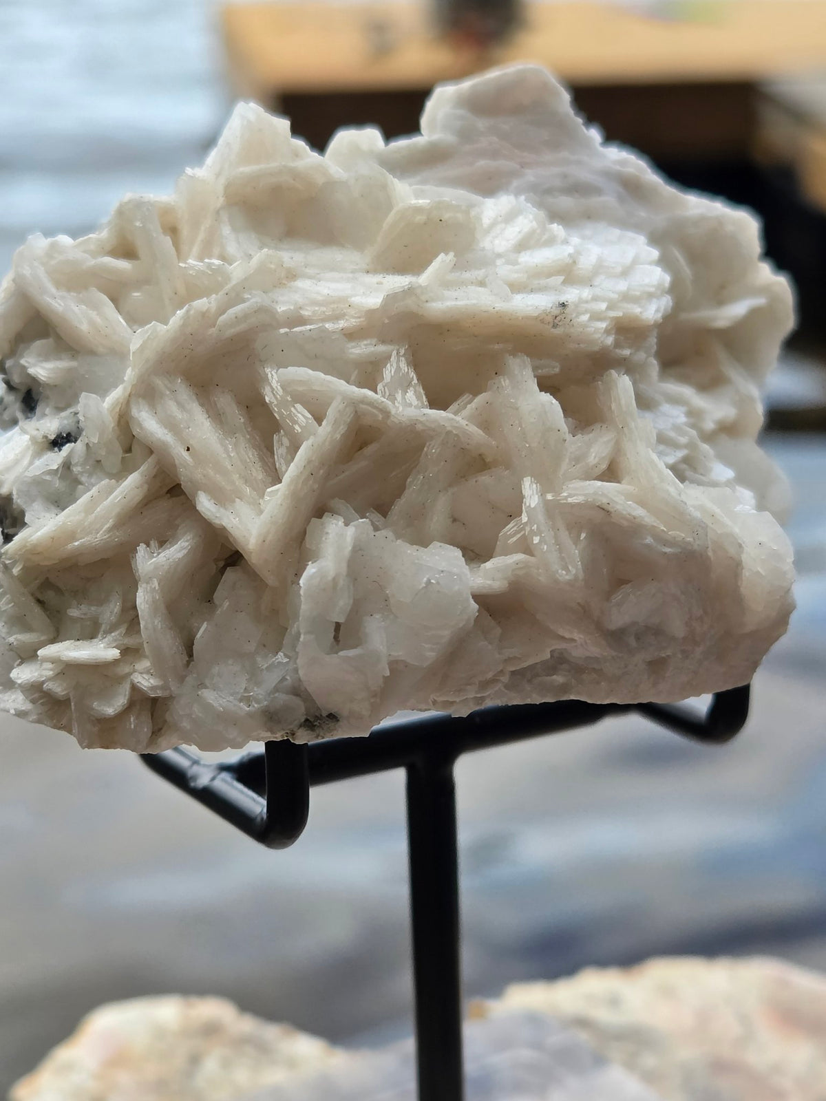 Pink calcite cluster side view on stand